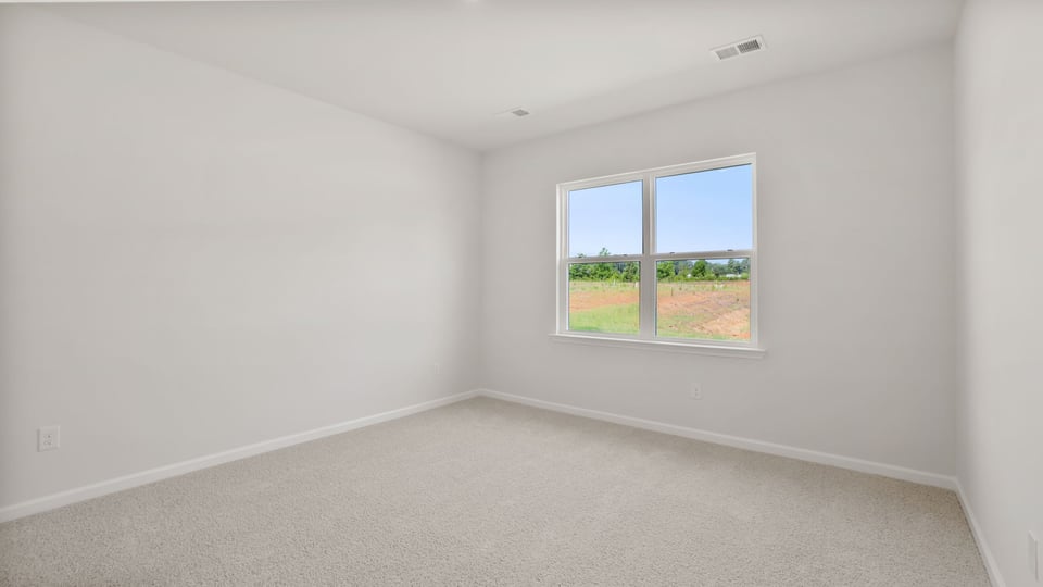 Bedroom with carpet and windows.