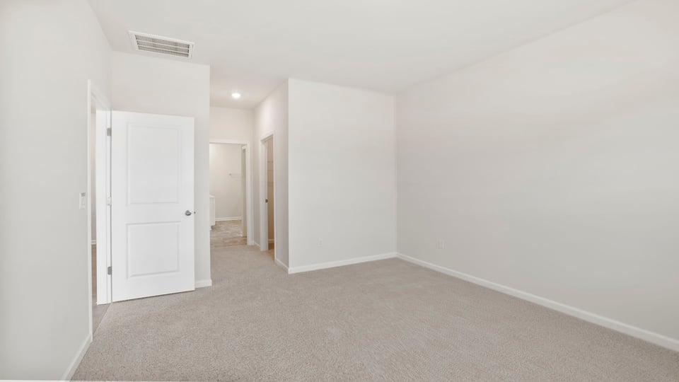 Bedroom with carpet and windows.