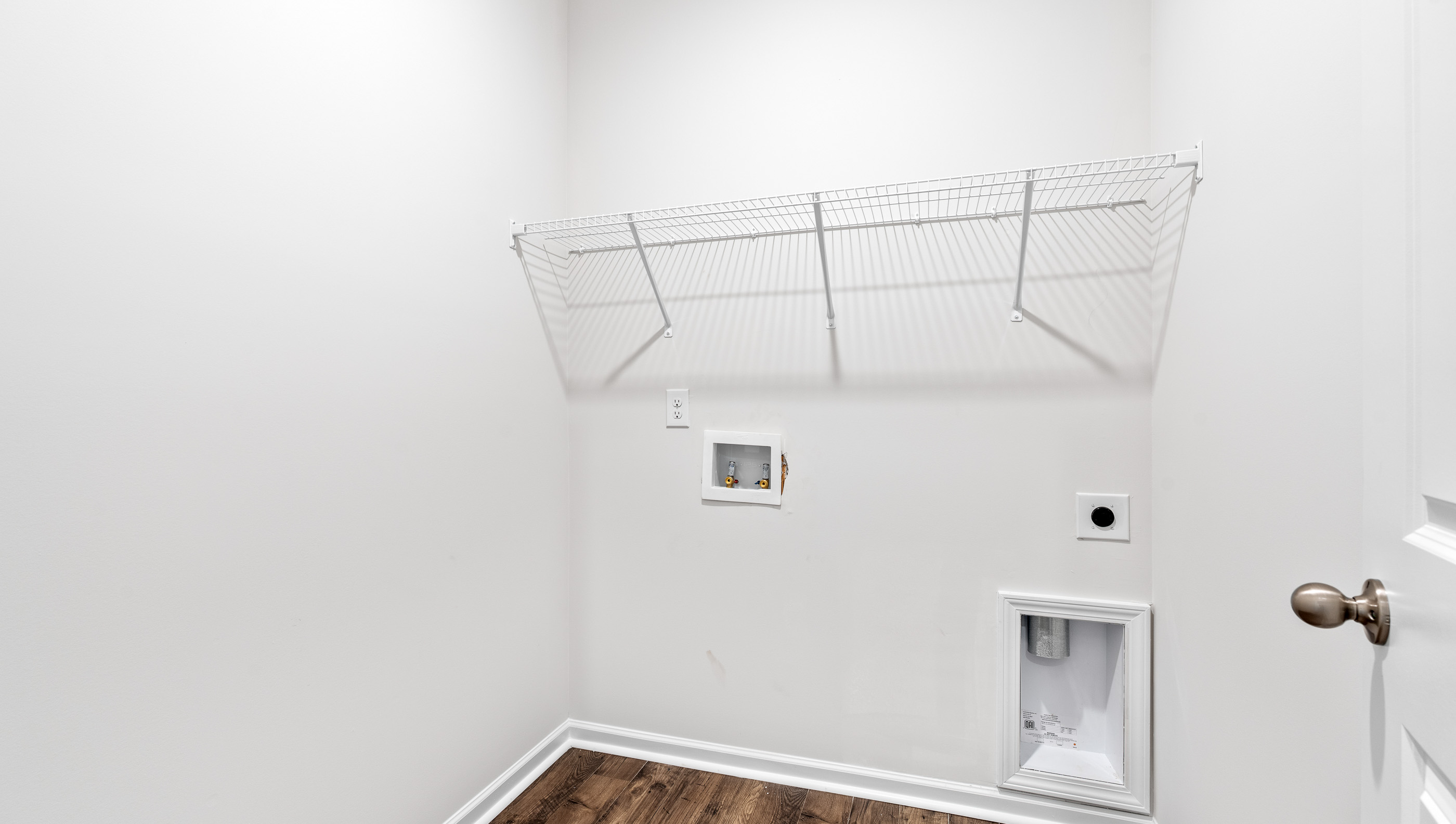 Walk-in laundry room with shelving.