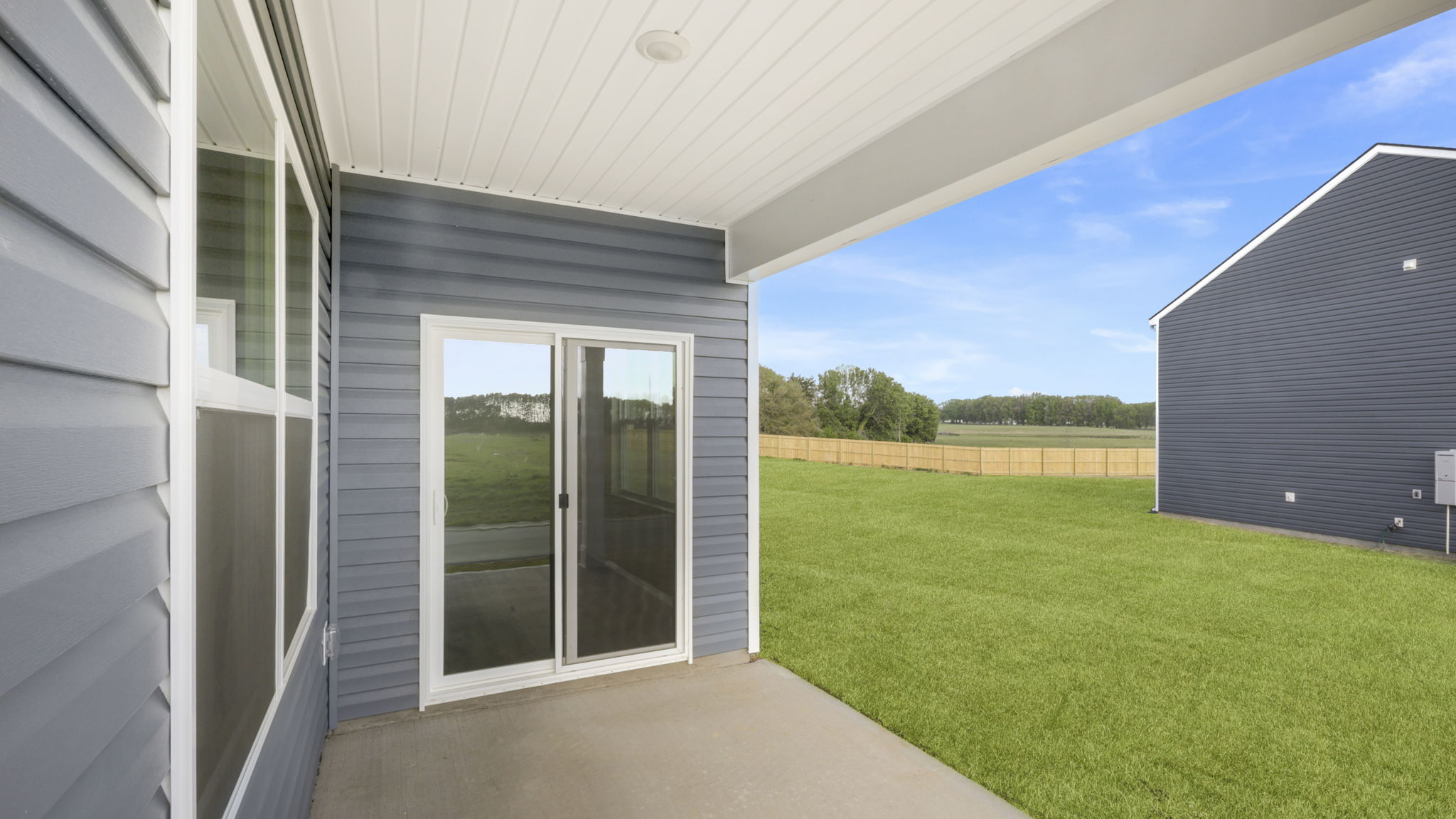 Back exterior of home with small patio.