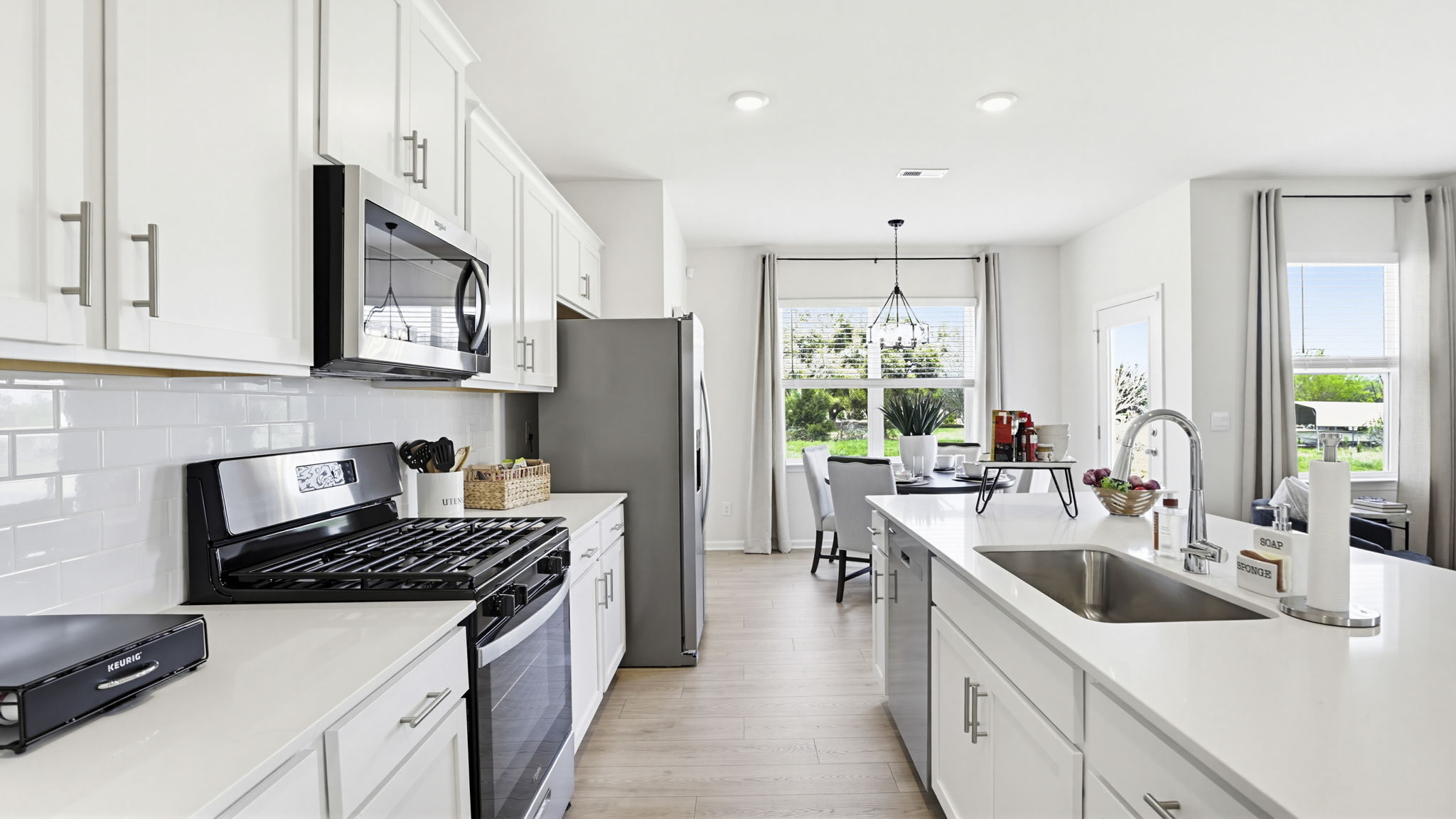 Kitchen and island with quartz countertops and stainless steel appliances.