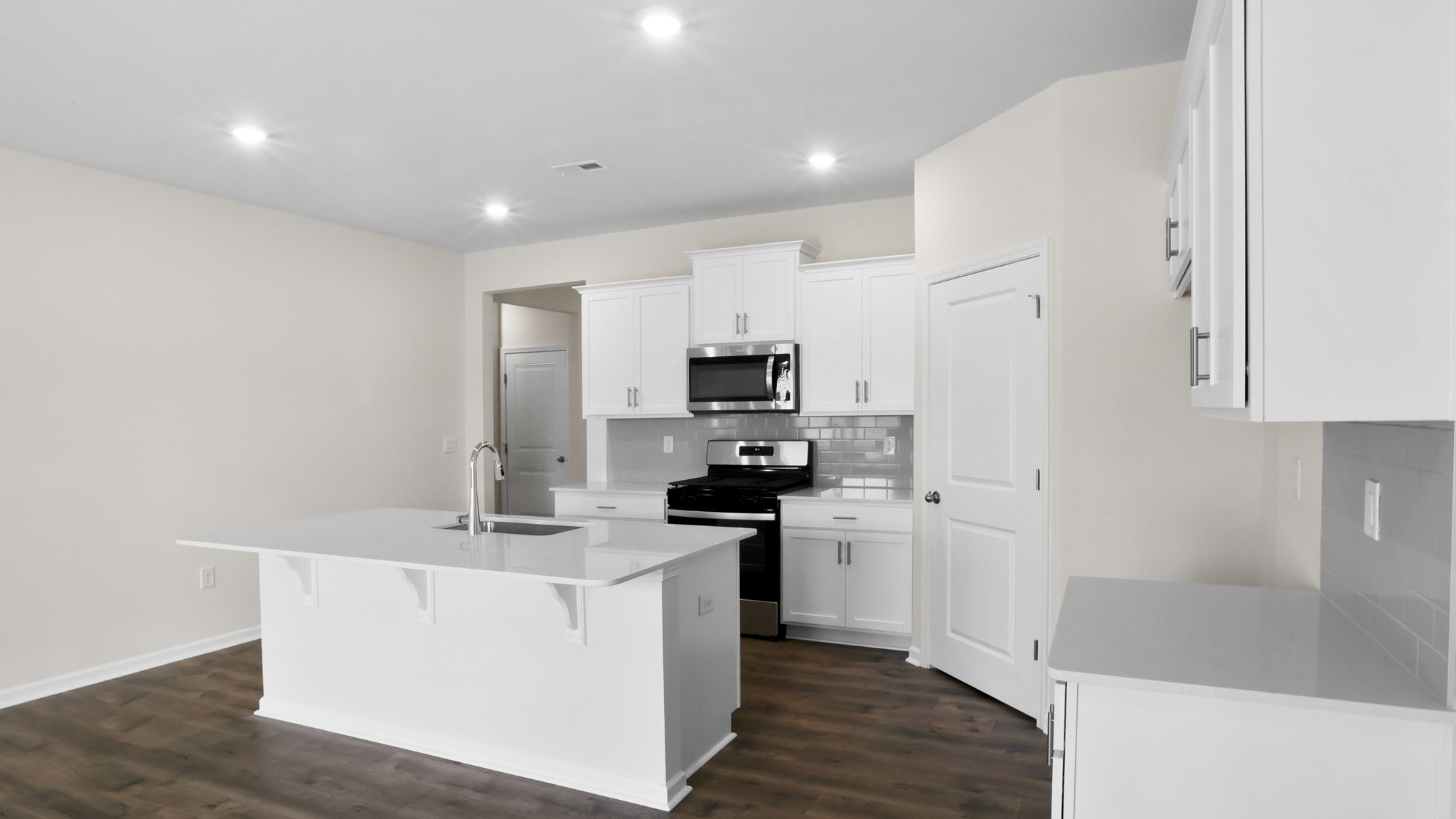 Kitchen and island with stainless steel appliances.