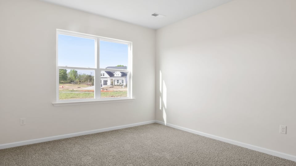 Bedroom with carpet and window.