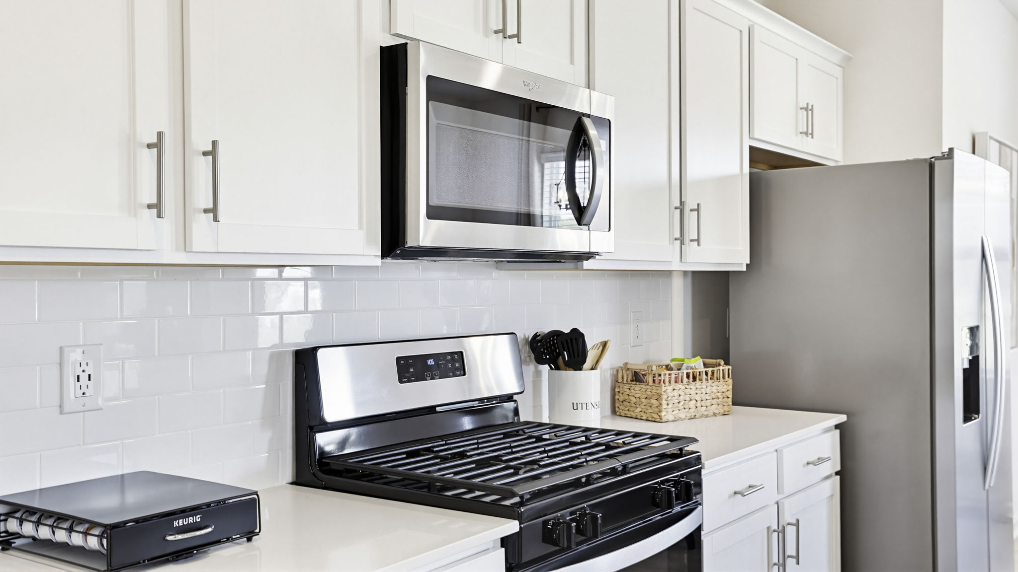 Kitchen and island with quartz countertops and stainless steel appliances.
