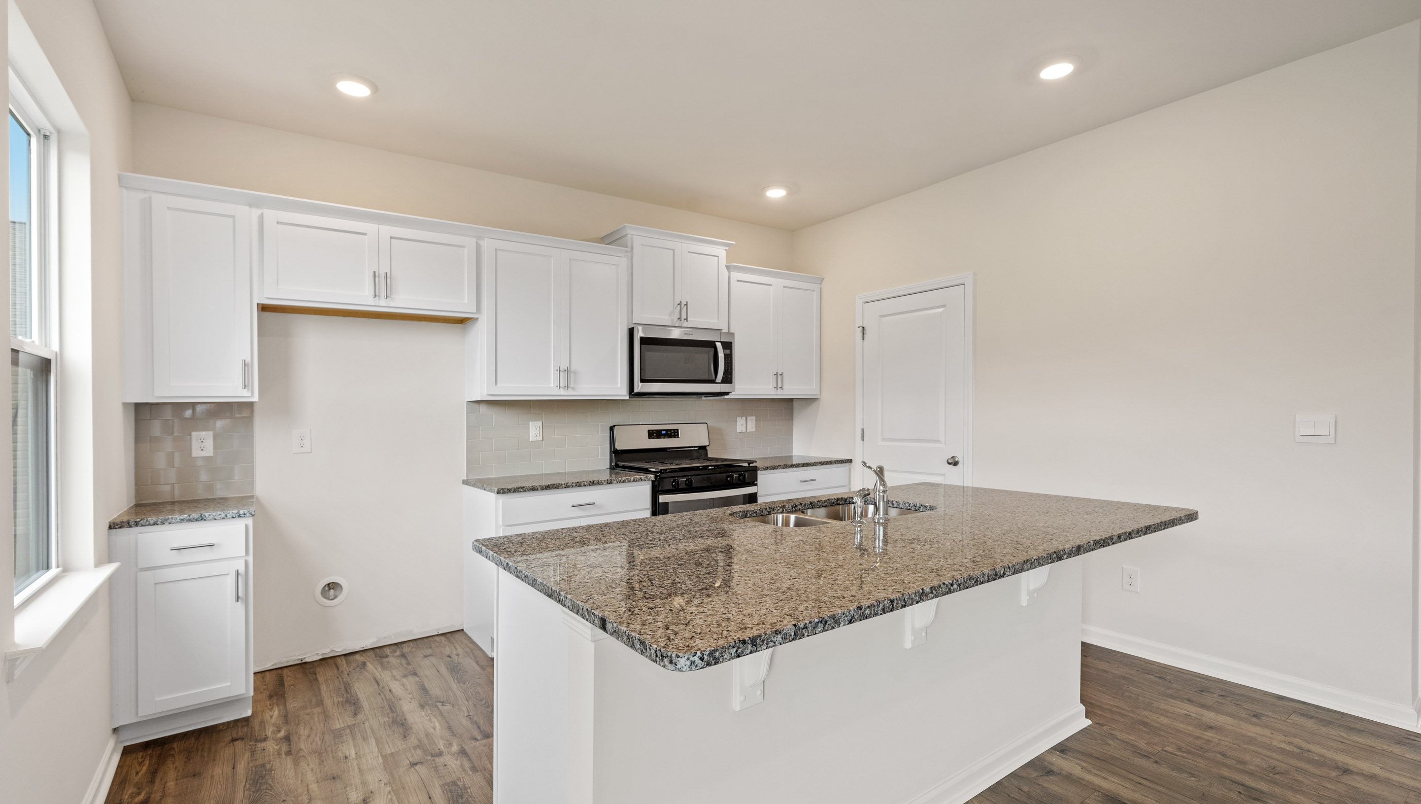 Kitchen and island with quartz counter tops.