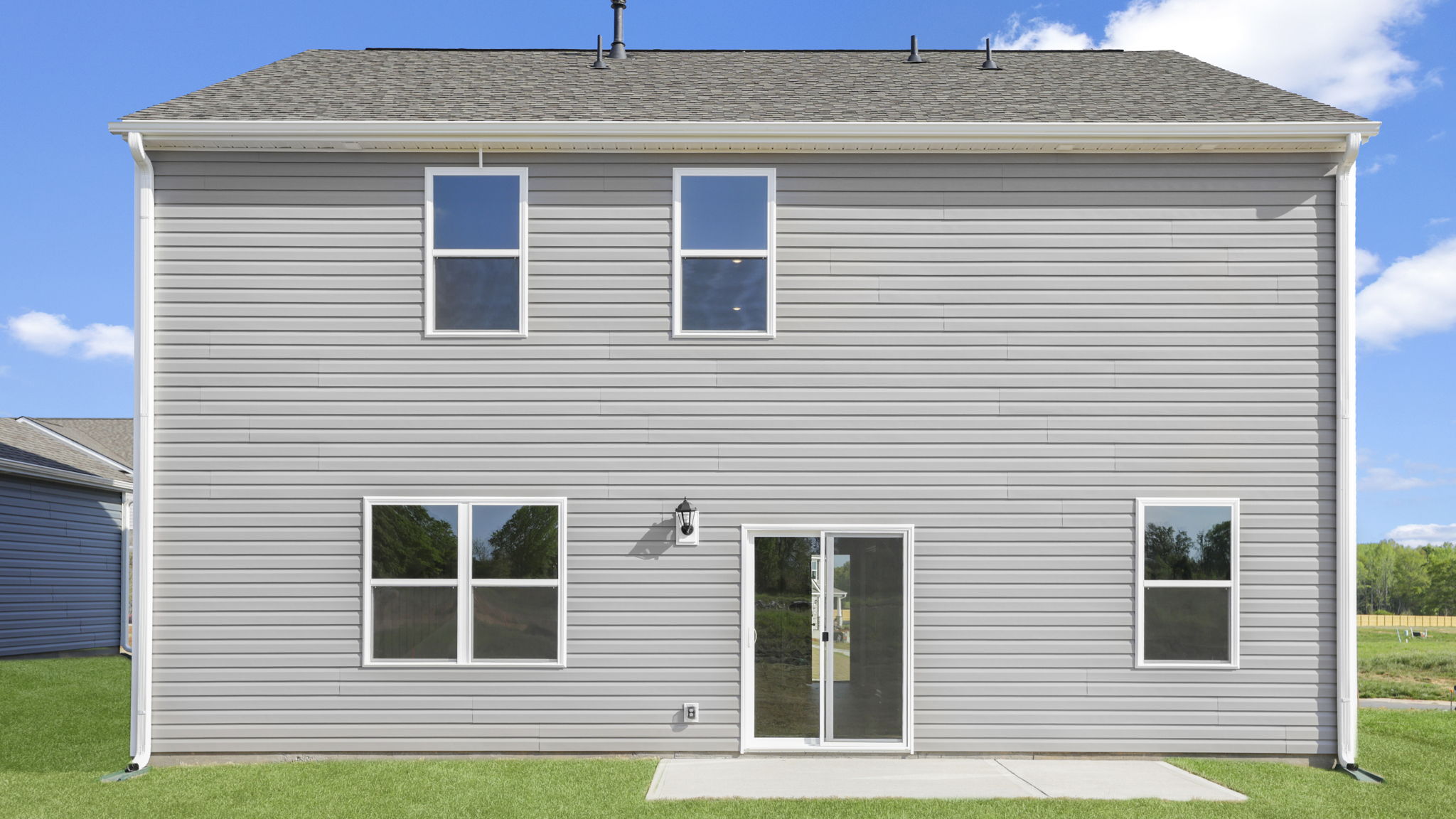 Back exterior of home with small patio.