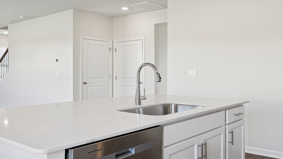 Kitchen island hosts the sink and dishwasher.