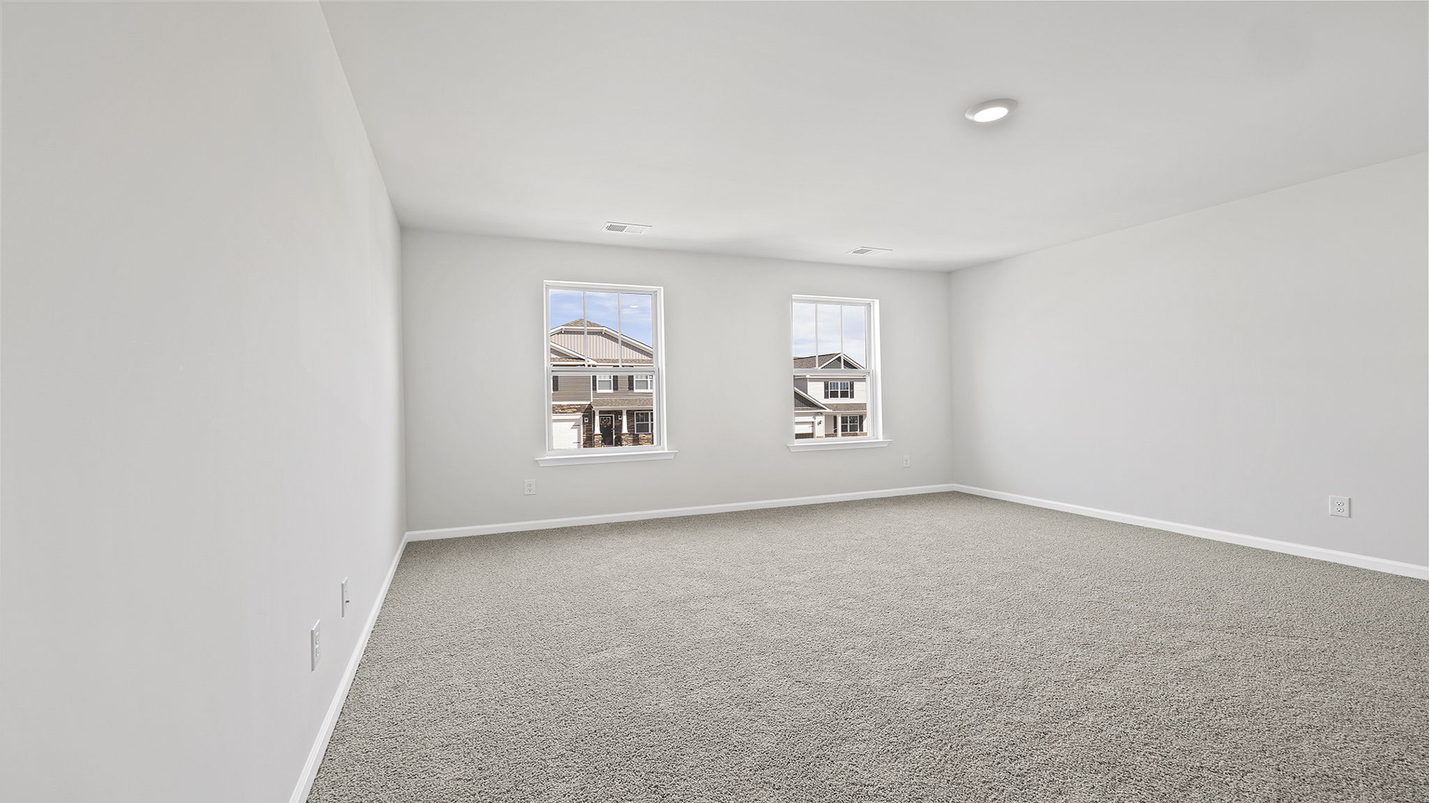 Primary bedroom with carpet and window.
