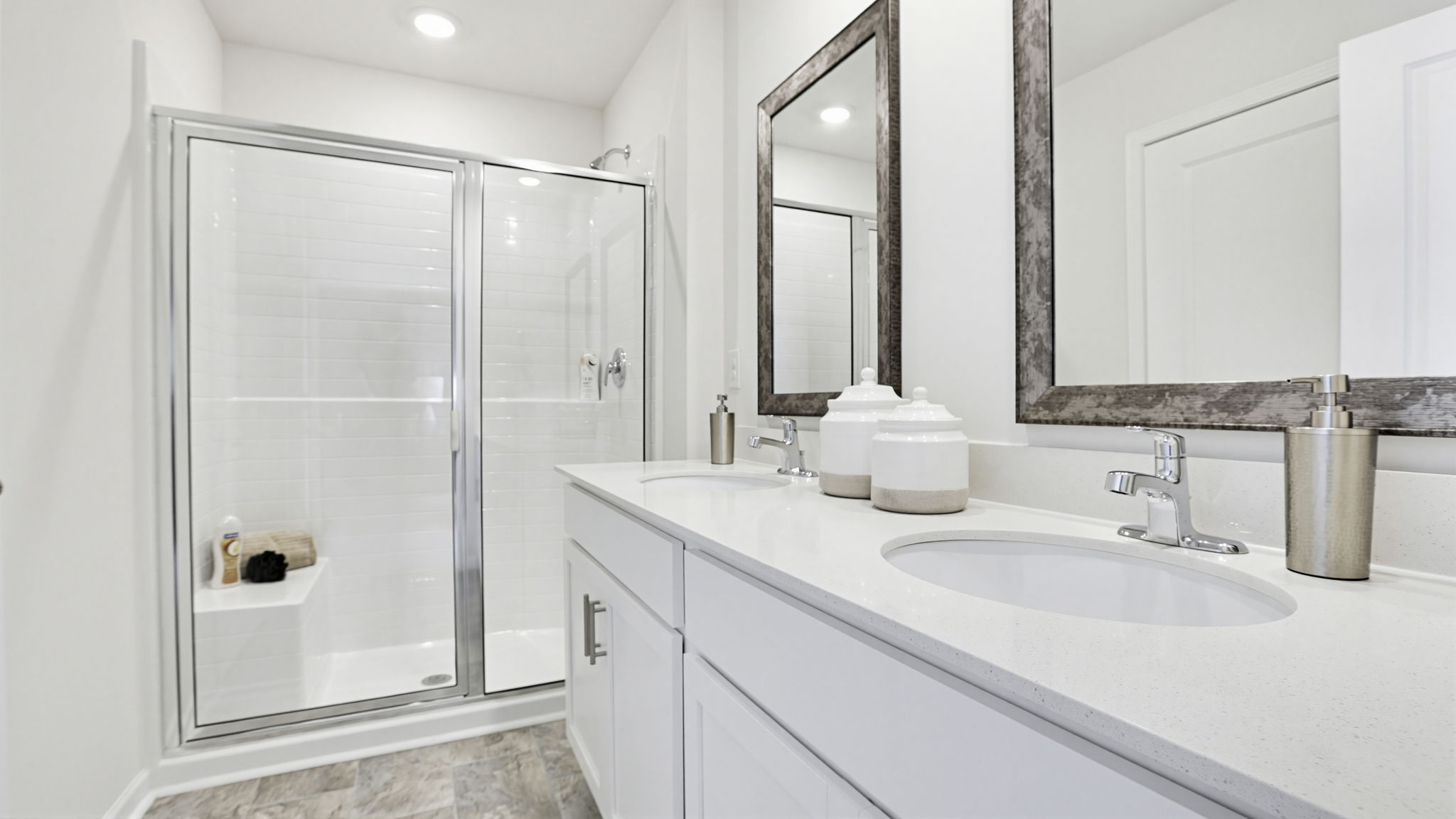 Bathroom with double vanity sink and walk in shower.