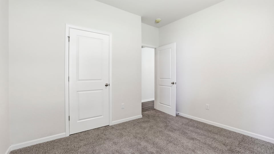 Bedroom with carpet and windows.