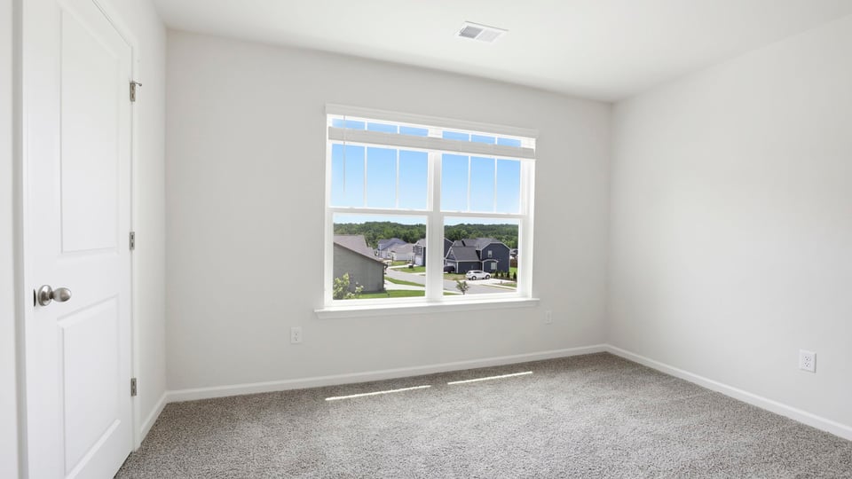 Bedroom with carpet and windows.