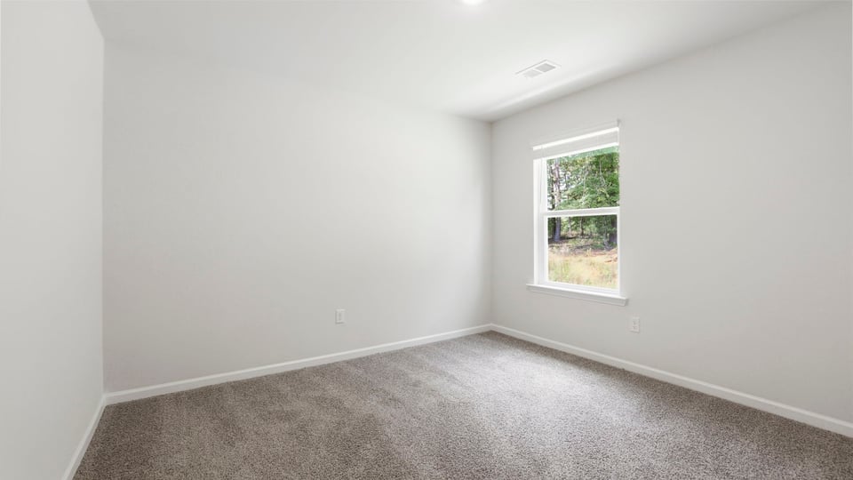 Bedroom with carpet and windows.