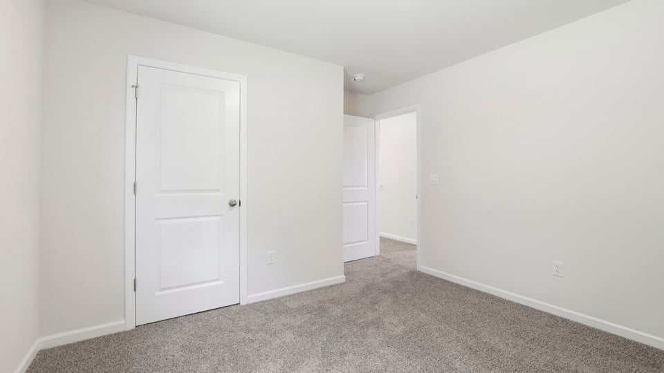 Bedroom with carpet and windows.