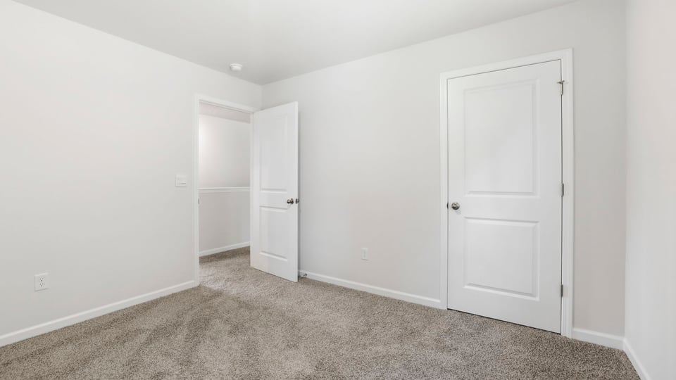 Bedroom with carpet and windows.