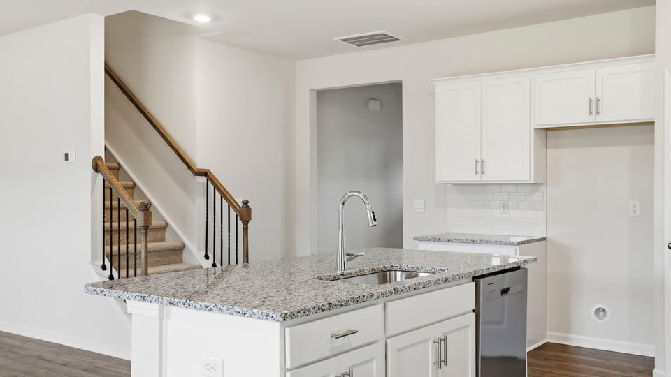 View of kitchen island and stairwell to the upper level.