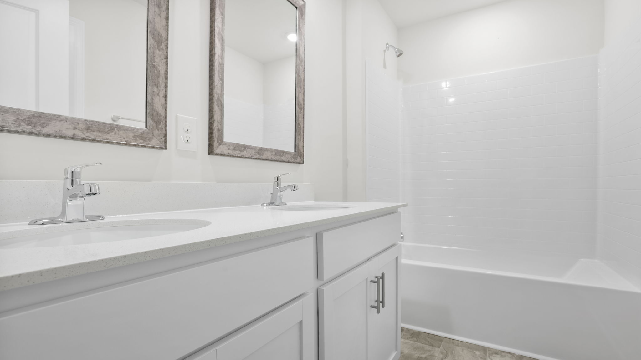 Bathroom with double vanity sink and walk in shower.