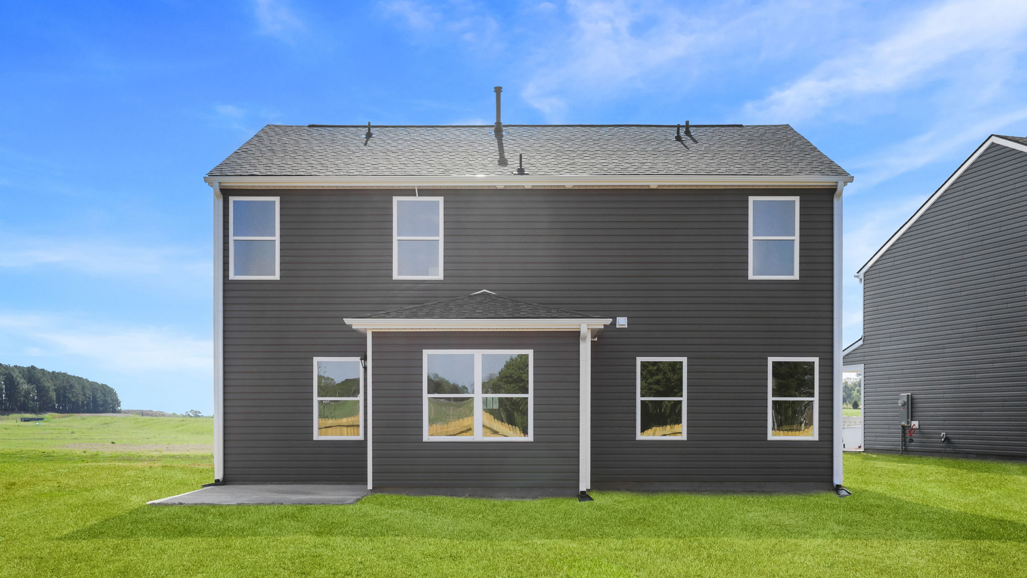 Back exterior of home with large backyard.