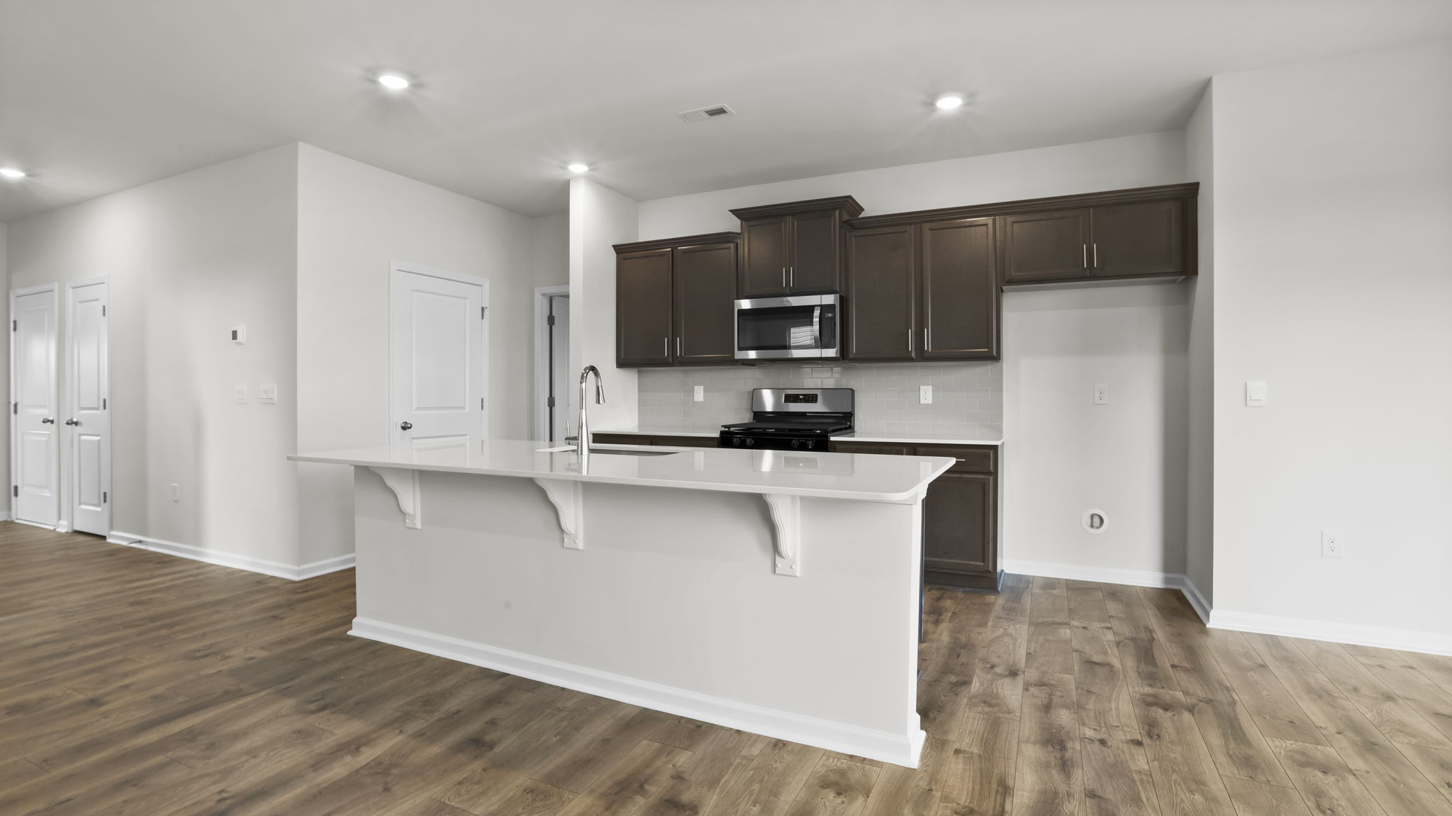 Kitchen and island with stainless steel appliances.