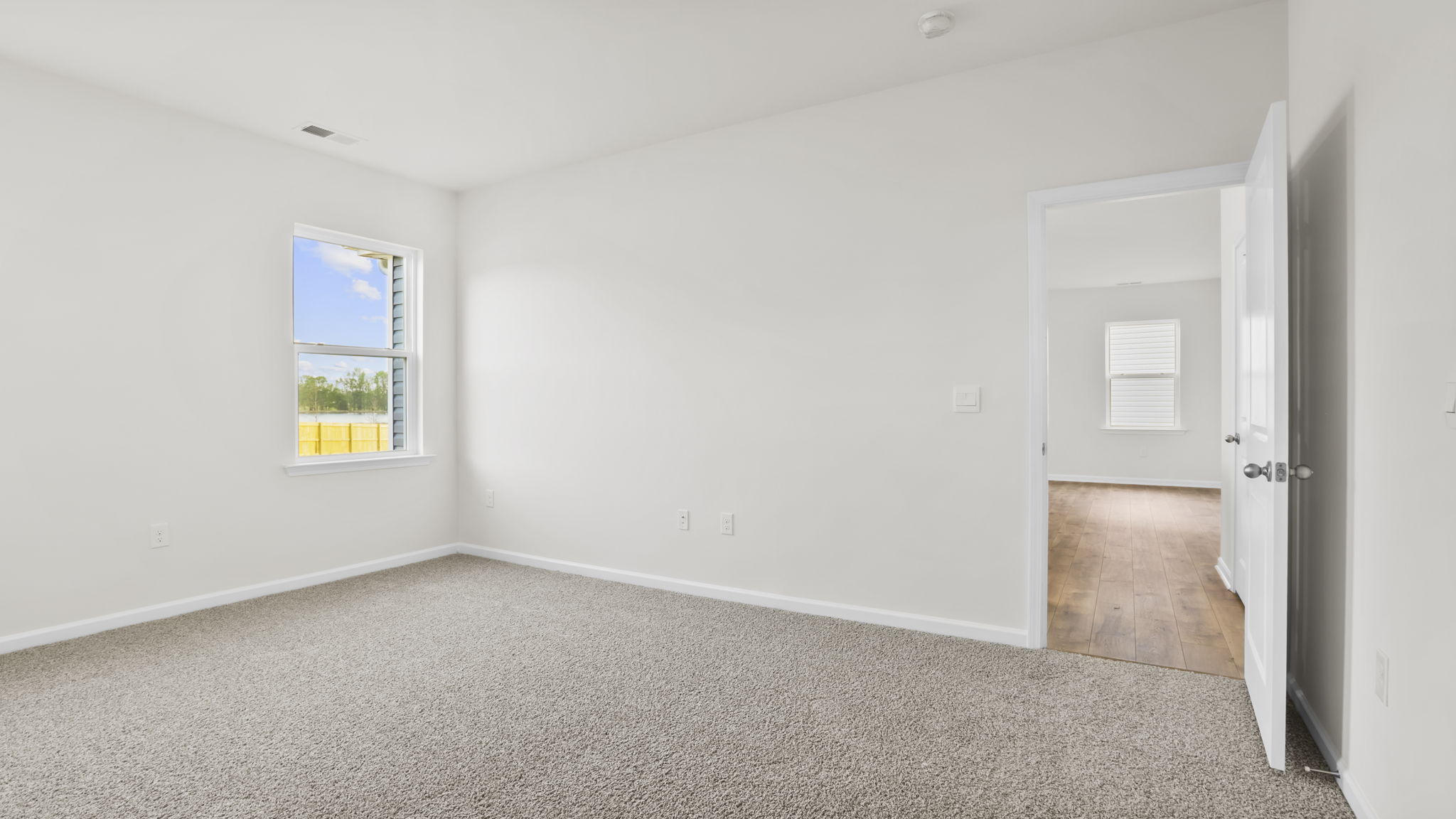 Bedroom with carpet and window.