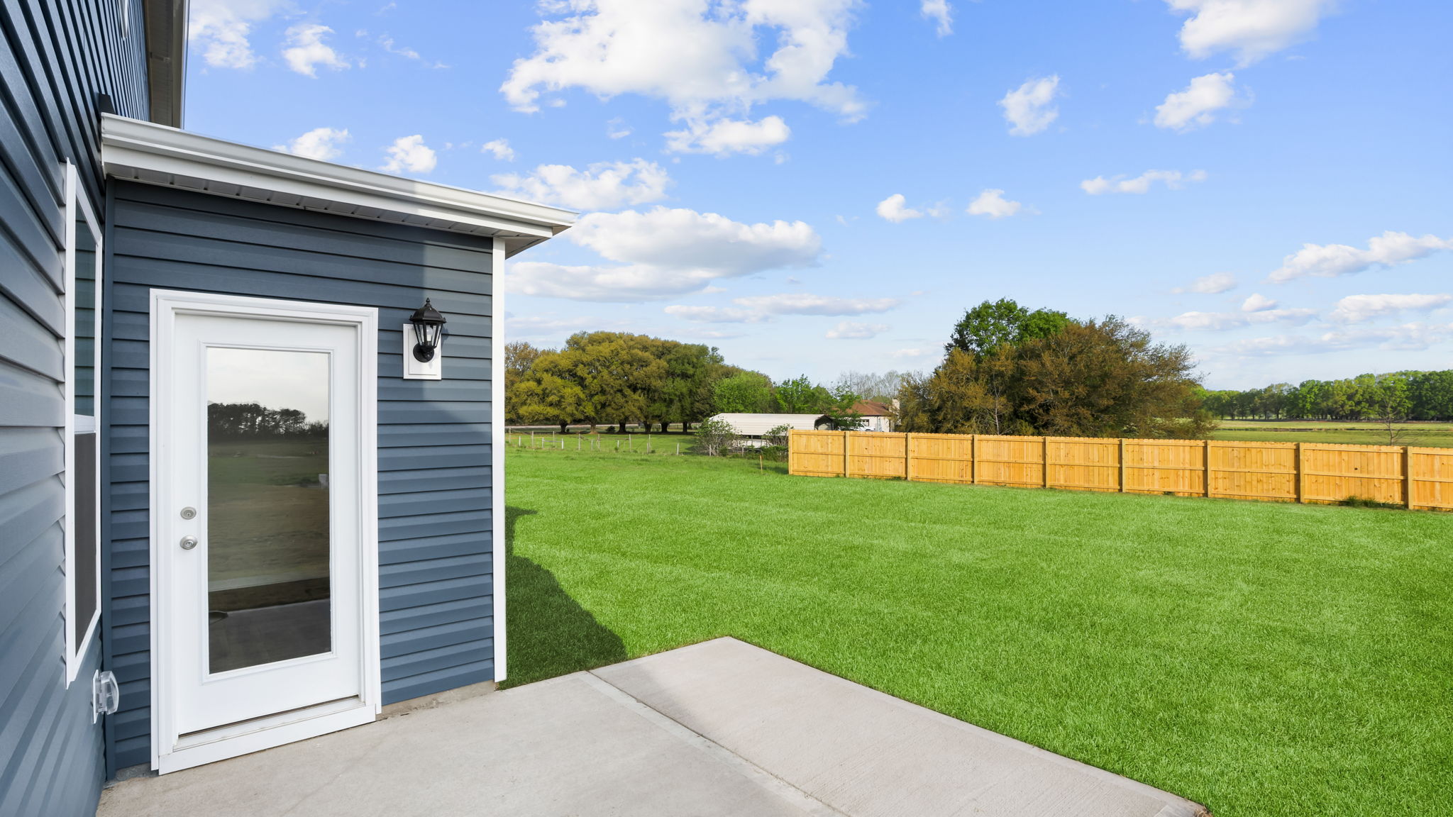 Back exterior of home with small patio.