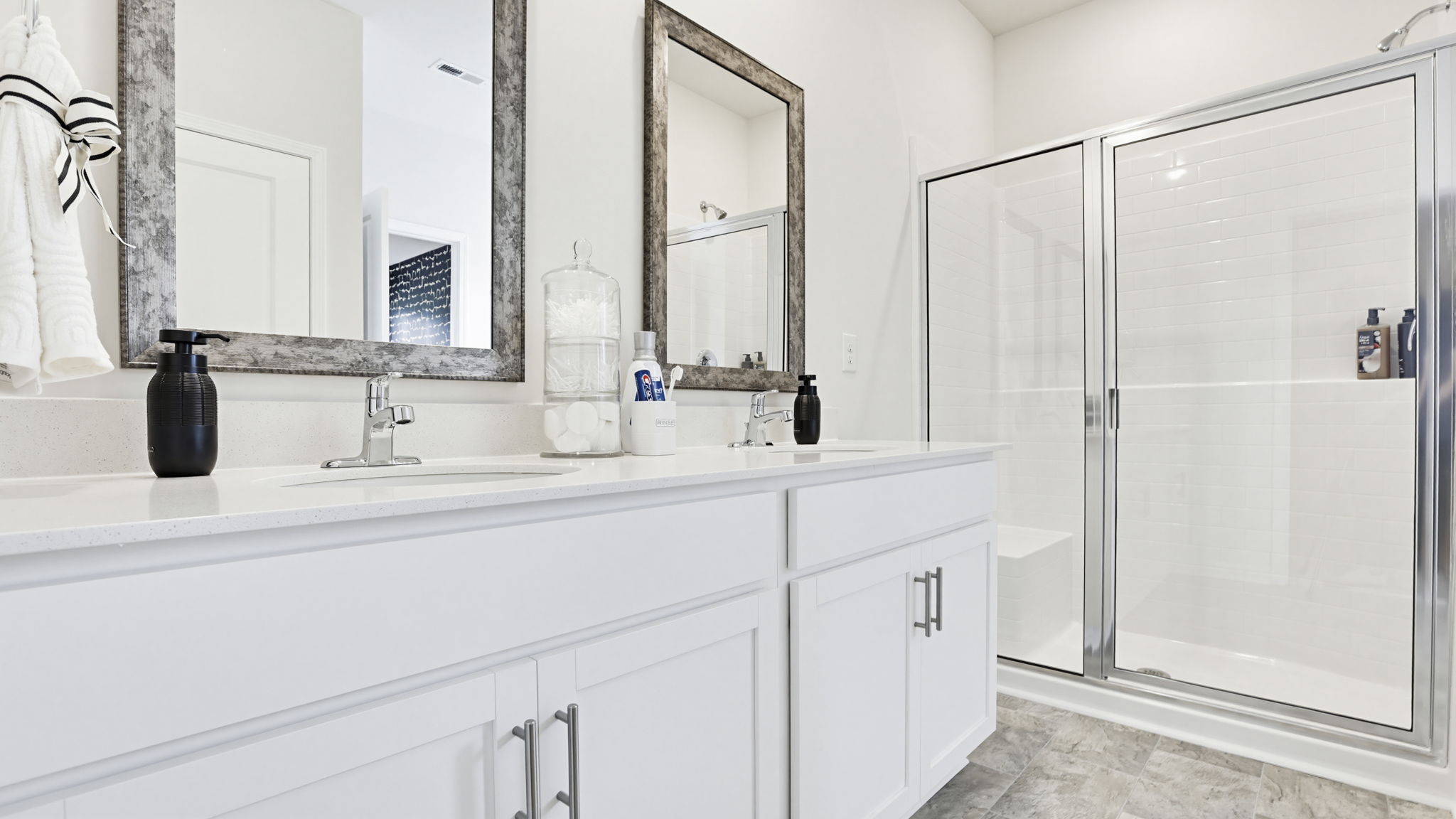Bathroom with double vanity sink and walk in shower.