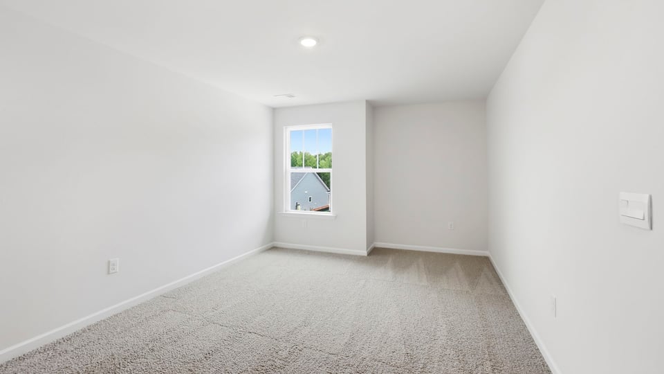 Loft area with carpet and windows.