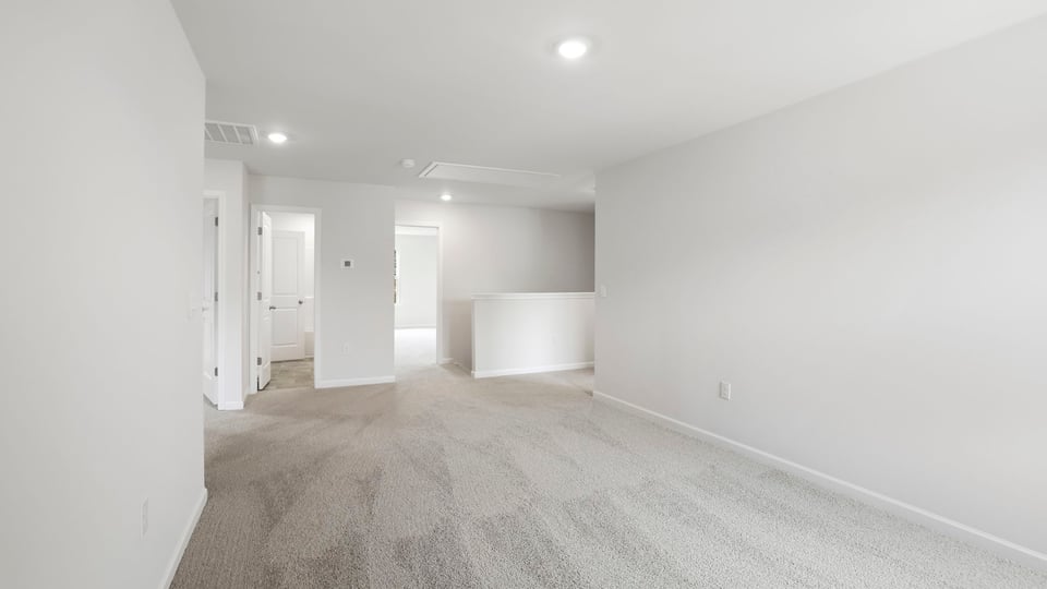 Loft area with carpet and windows.