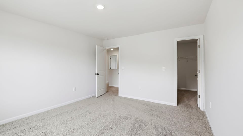 Bedroom with carpet and windows.