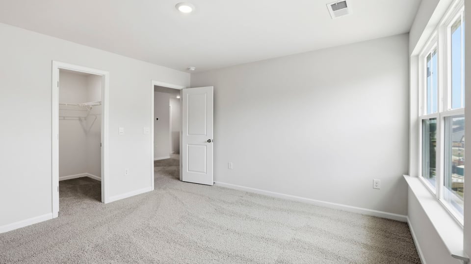 Bedroom with carpet and windows.