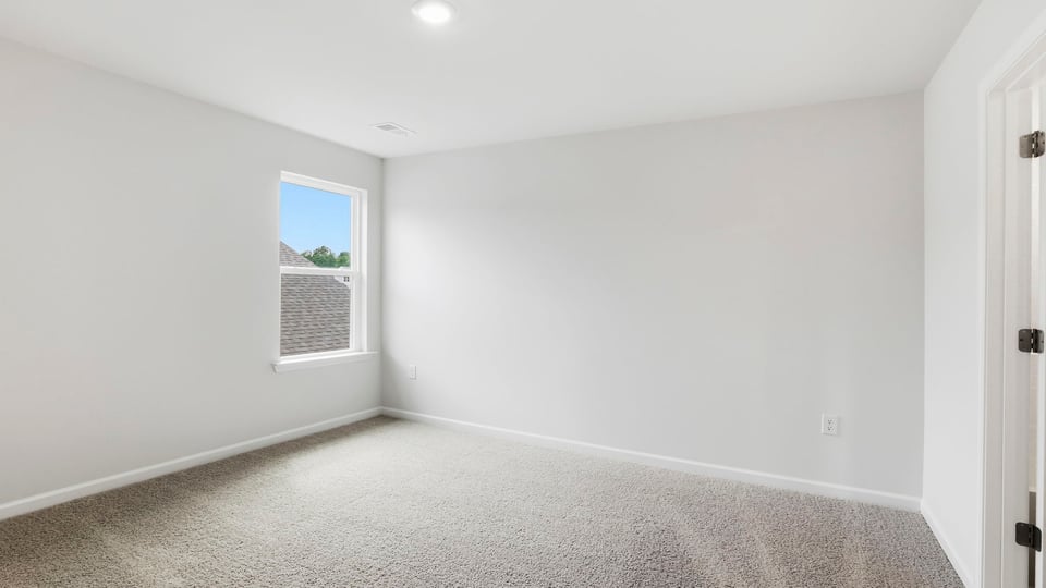Bedroom with carpet and windows.