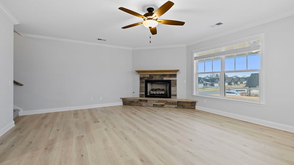 Family room with ceiling fan and fireplace.