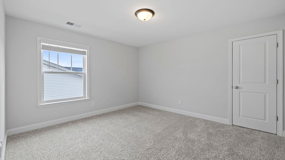 Bedroom with carpet and window.