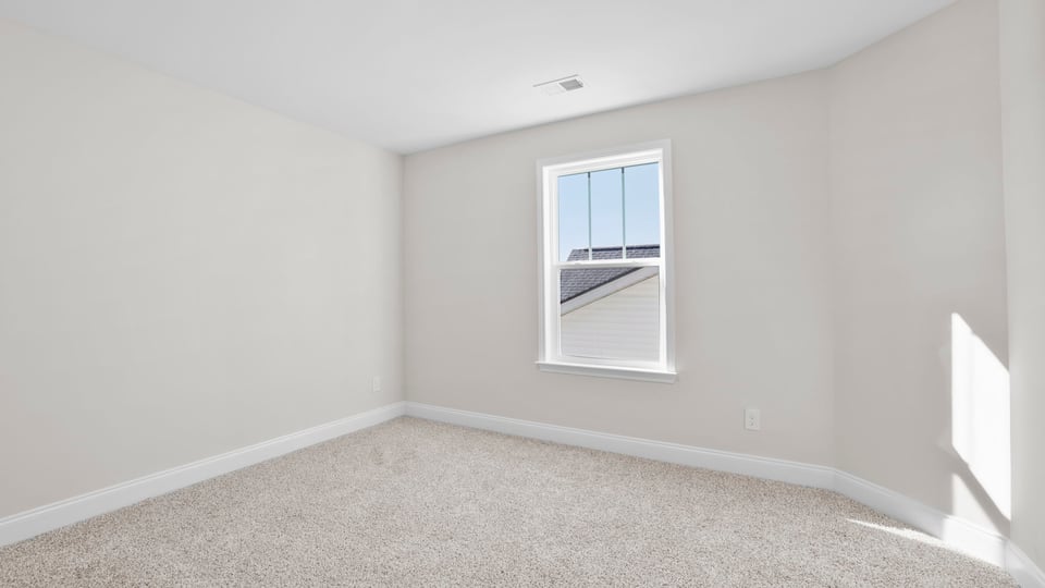 Bedroom with carpet and window.