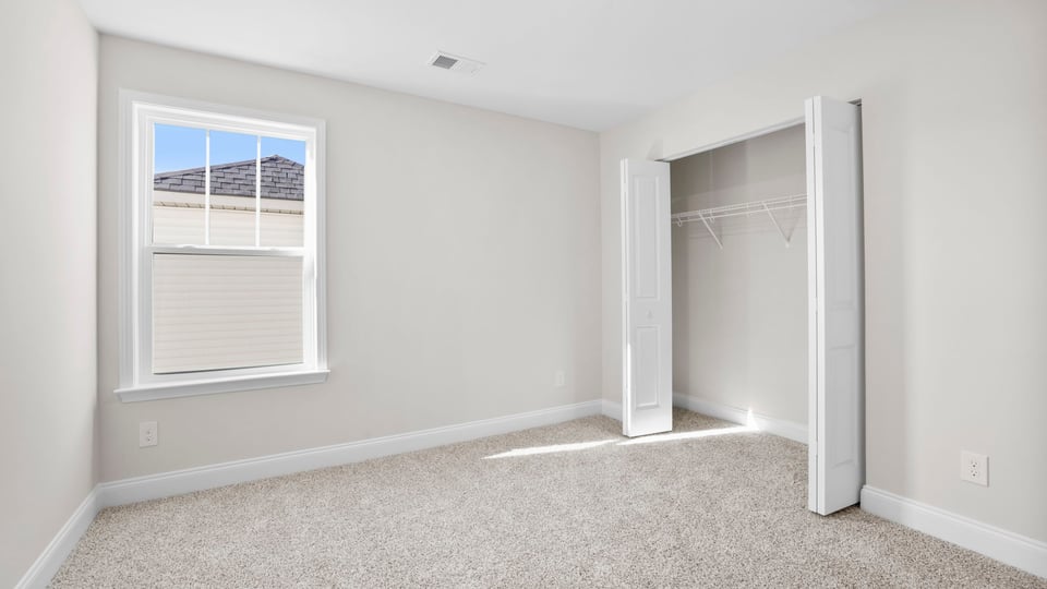Bedroom with carpet and window.