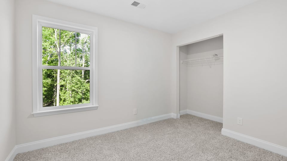 Bedroom with carpet and window.