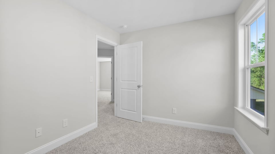 Bedroom with carpet and window.