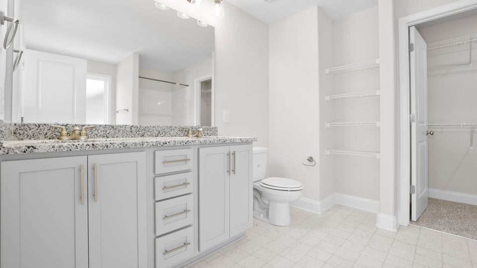 Bathroom with double vanity sink and closet.