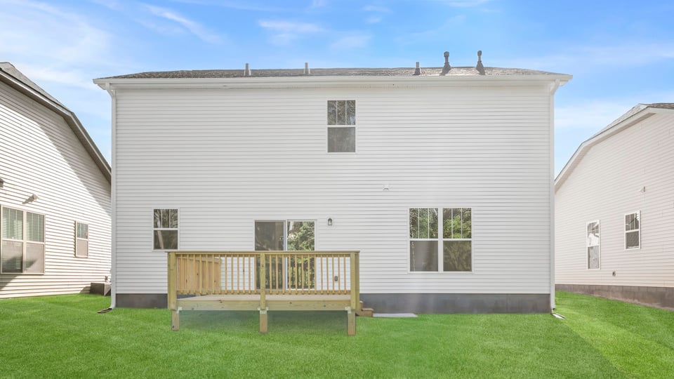 Back exterior of home with large backyard.
