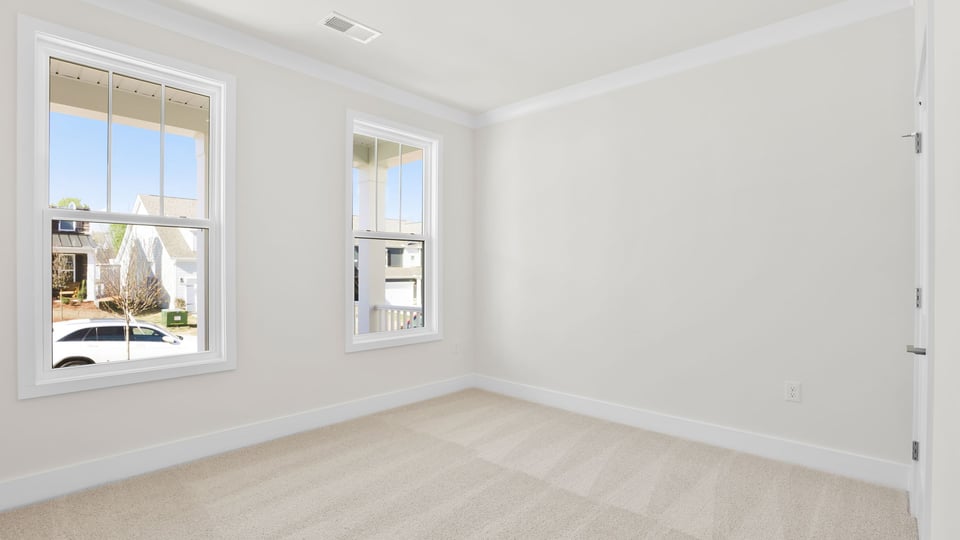 Bedroom with carpet and windows.