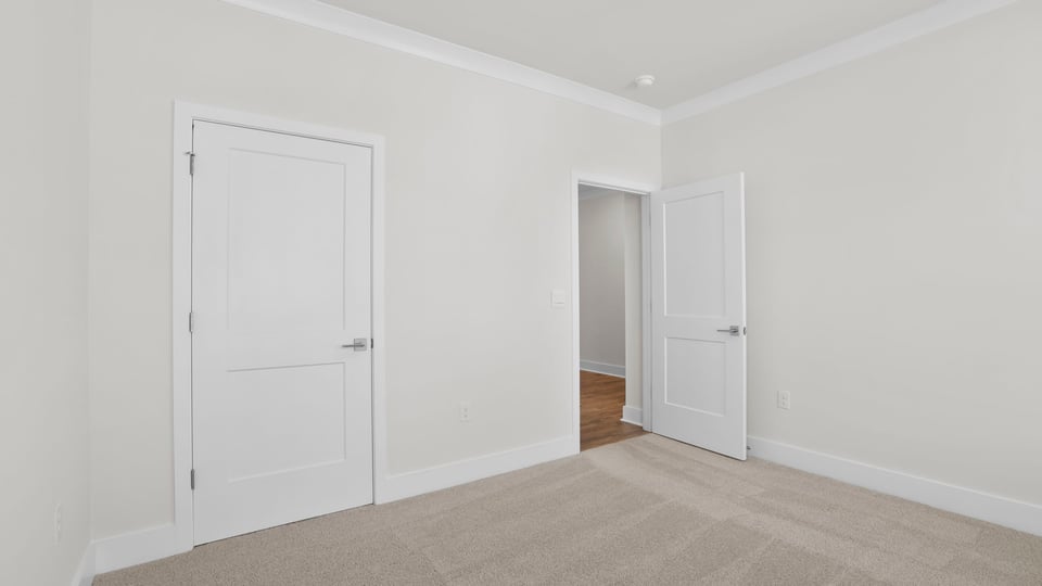 Bedroom with carpet and windows.