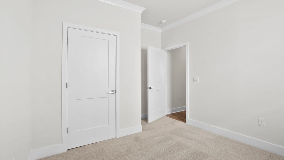 Bedroom with carpet and windows.
