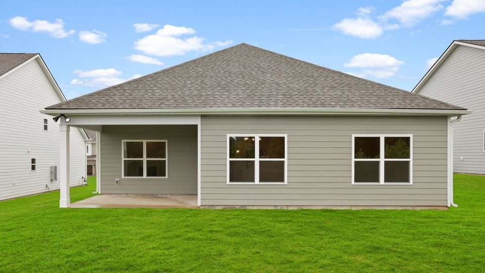 Back exterior of home with large backyard,