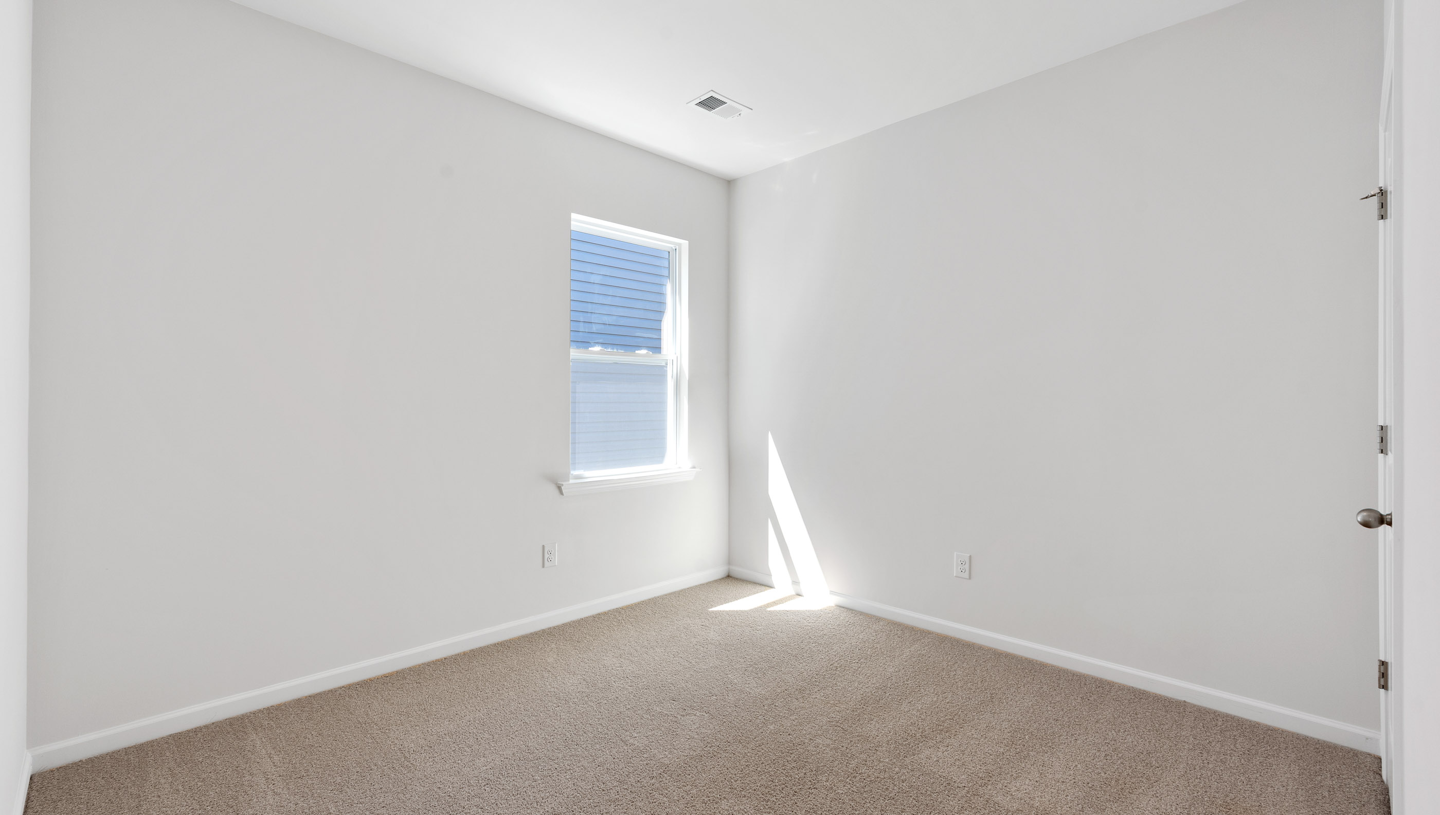 Bedroom with carpet and windows.