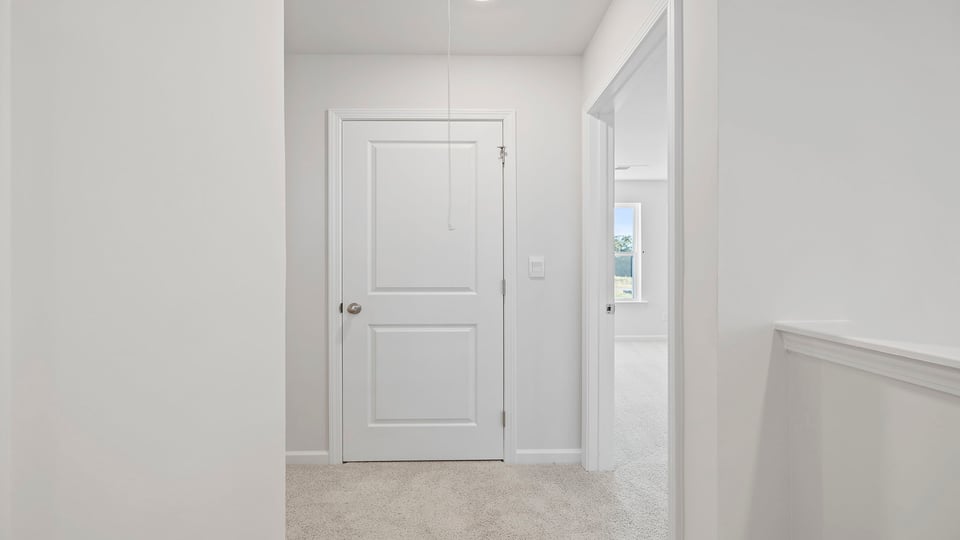 Hallway to bedrooms with carpet.