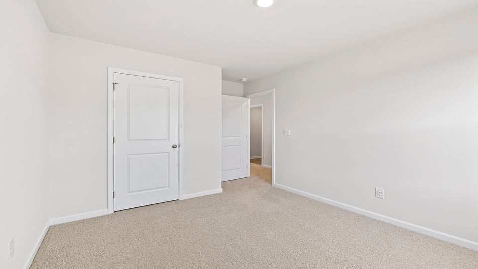 Bedroom with carpet and windows.