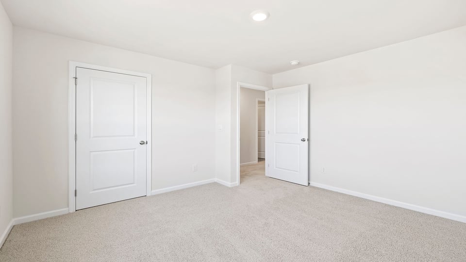 Bedroom with carpet and windows.
