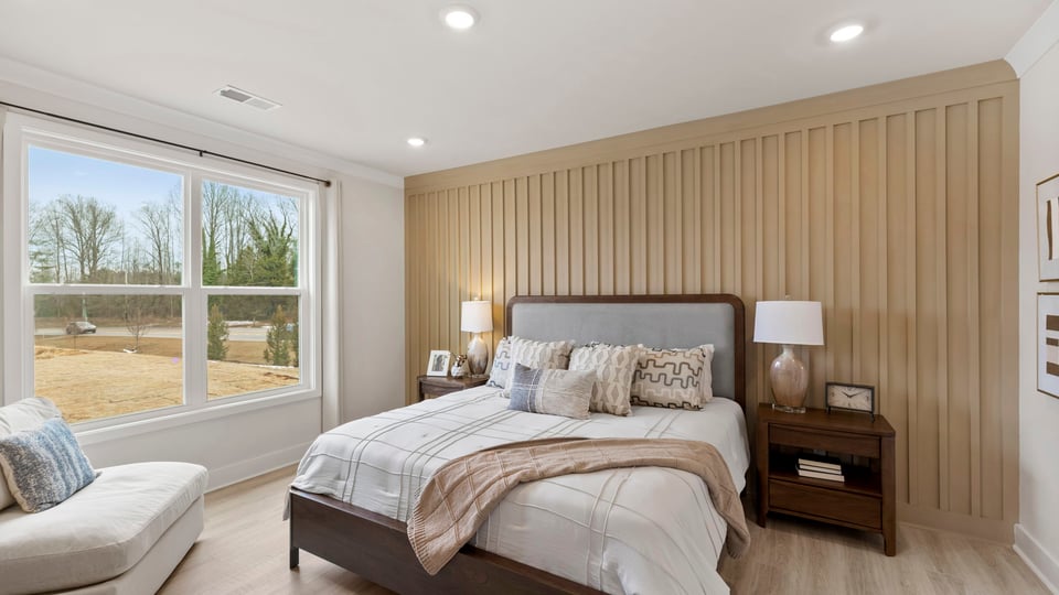 Primary bedroom with windows and carpet.