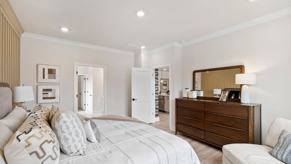 Primary bedroom with windows and carpet.