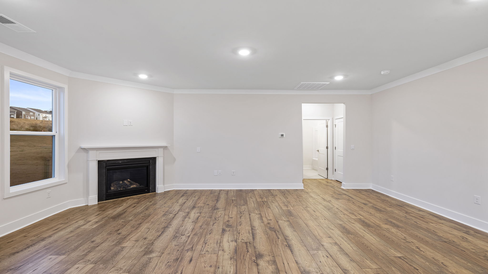View of the living area with gas log fireplace and lots of windows.