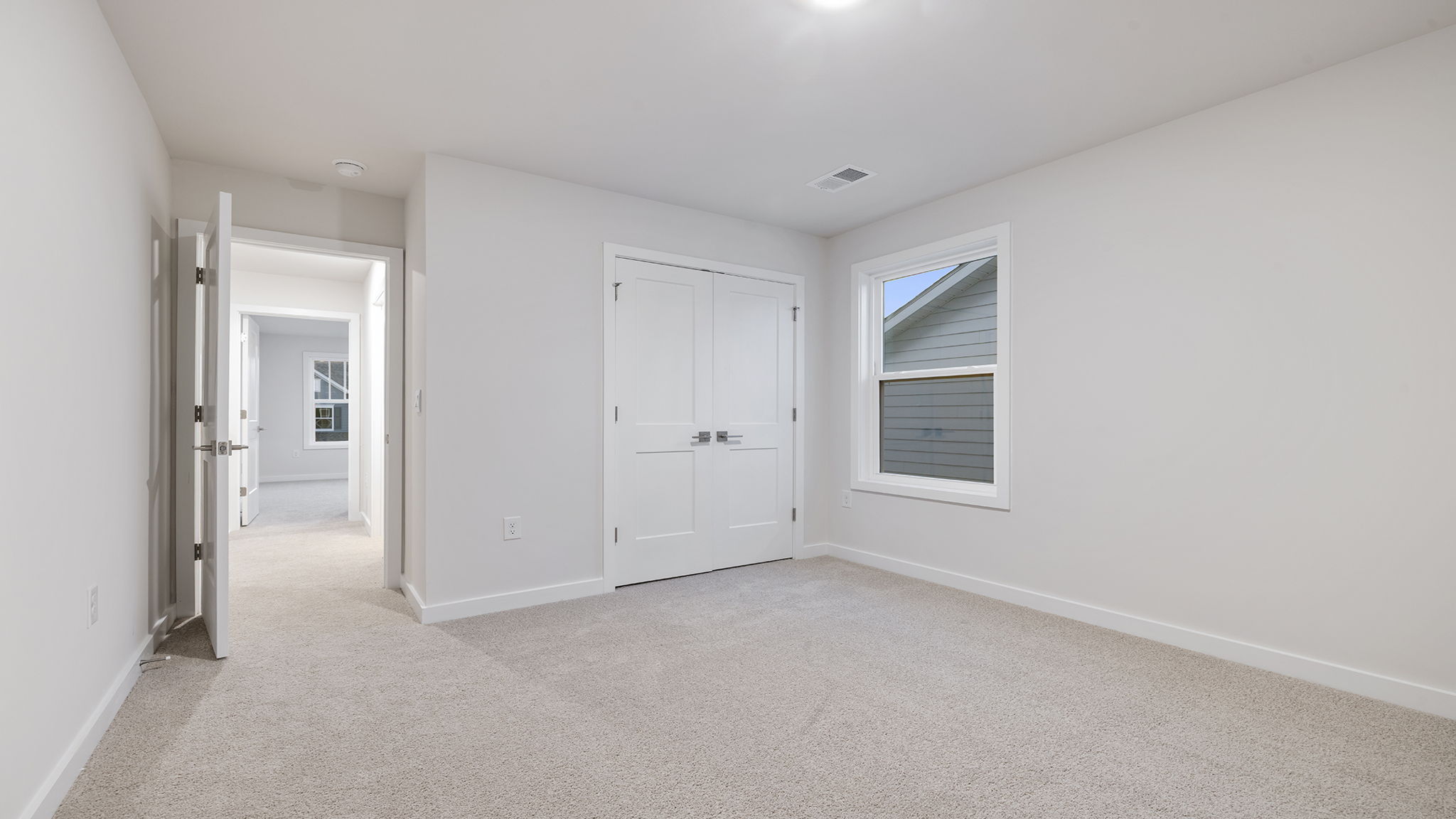 Bedroom with carpet and windows.